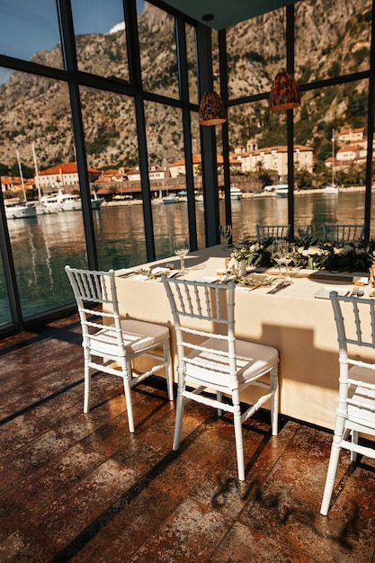 Romantic table setting for wedding reception with sea view through the windows