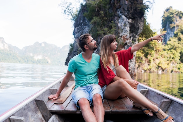 Free photo romantic traveling couple spending vacation time together , sitting on long tail boat, exploring wild nature of khao sok national park.