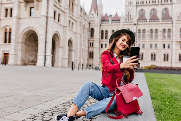 Romantic woman in casual clothes making selfie with cup of tea