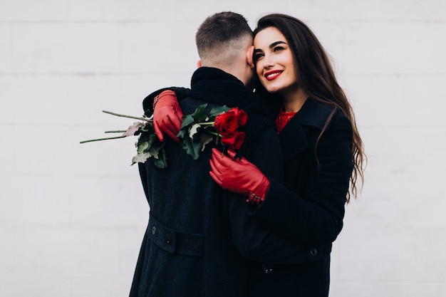 Free Photo romantic woman with flowers embracing man