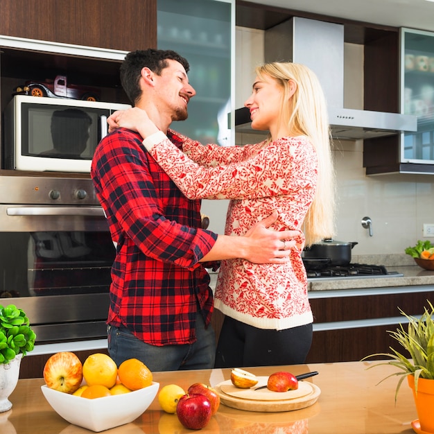 Free Photo romantic young couple looking at each other in the kitchen