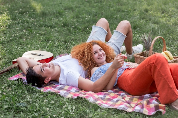 Free photo romantic young couple picnicking together in the park