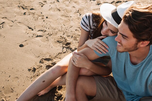 Romantic young couple sitting next to the sea