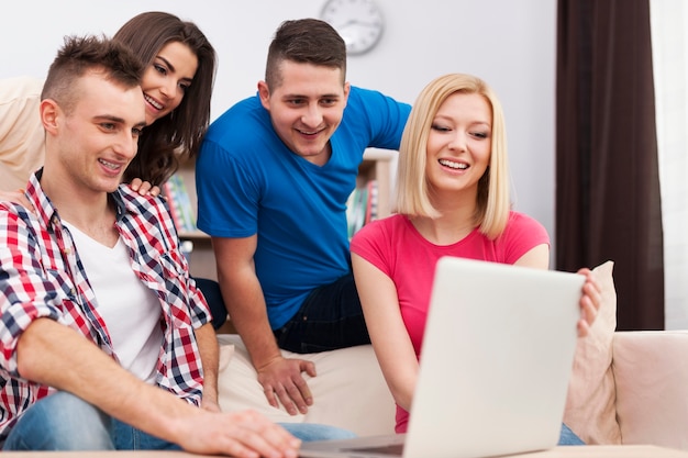 Roommates using laptop in living room