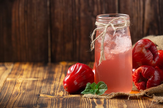 Free Photo rose apple juice on dark wooden surface