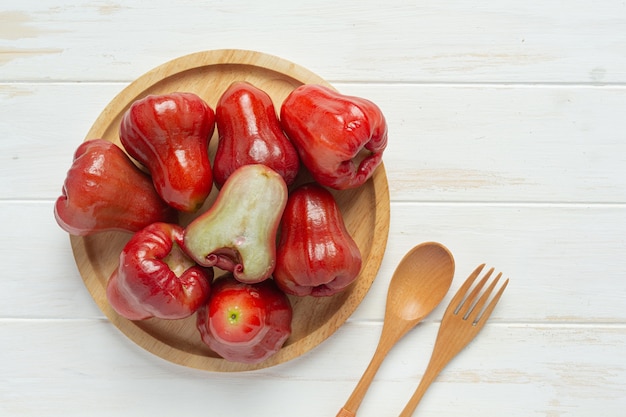 Rose apple on white wooden surface