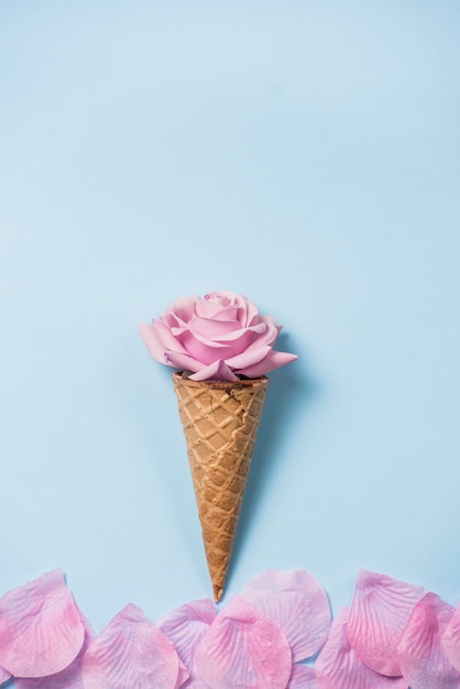 Free photo rose bud in waffle cone on table