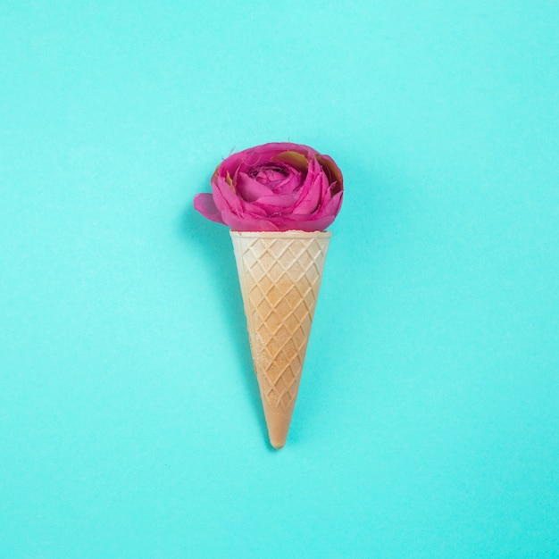 Rose flower in waffle cone on table