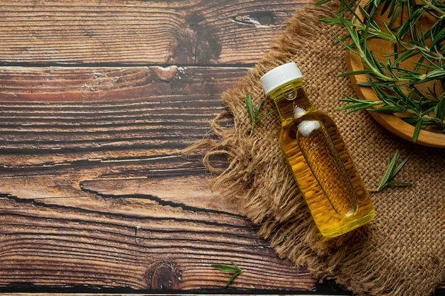 Rosemary oil in bottle with rosemary plants