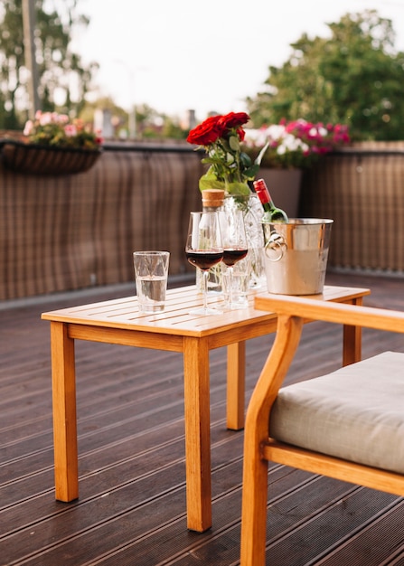 Roses; wine glass and ice bucket on wooden table in restaurant