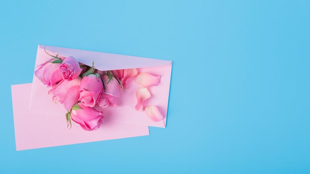 Roses with envelope on blue table