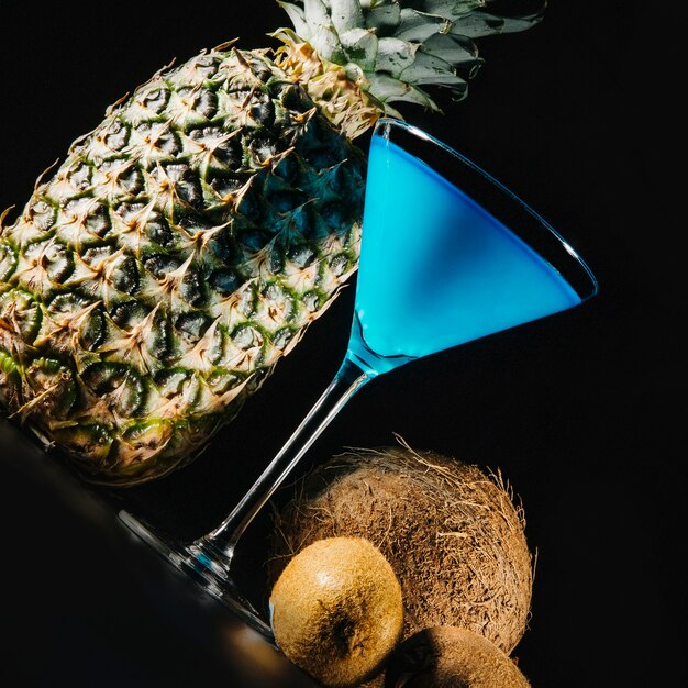 Rotate view of cocktail and exotic fruits on black background