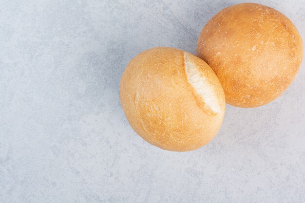 Round burger buns on stone surface