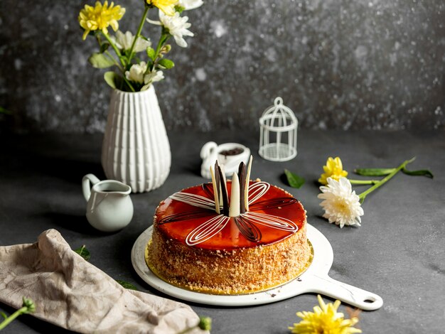 Free photo round cake decorated with caramel syrup white and dark chocolates