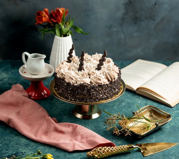 Free photo round cake decorated with chocolate grates and cream with coffee