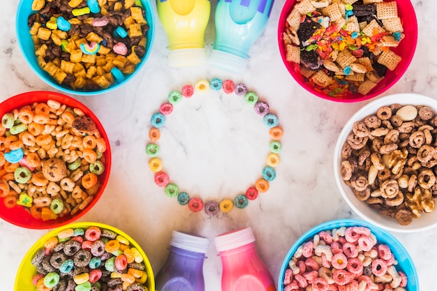 Free Photo round frame from cereals with bowls and bottles 