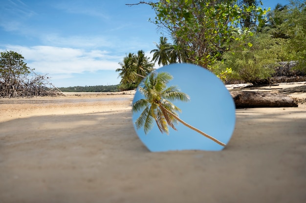 Free photo round glass mirror at the beach reflecting landscape