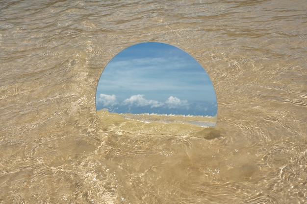 Free Photo round glass mirror at the beach reflecting landscape