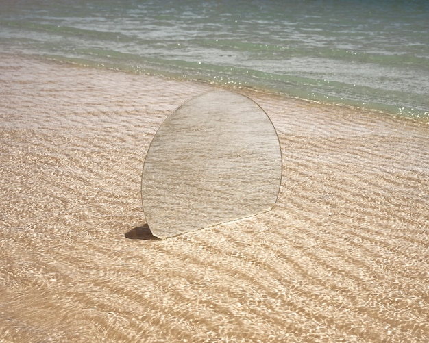 Round glass mirror at the beach reflecting landscape