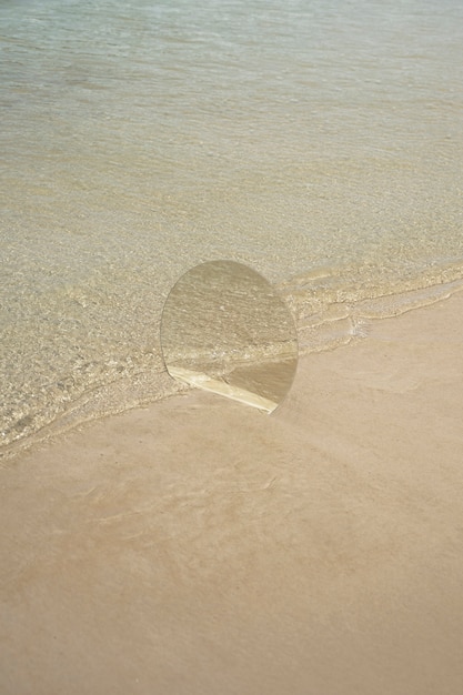 Free photo round glass mirror at the beach reflecting landscape