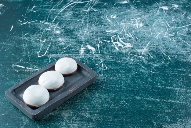 Round glazed biscuits on black plate. 