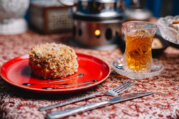 Round portioned cake covered with cake crumbles served with tea