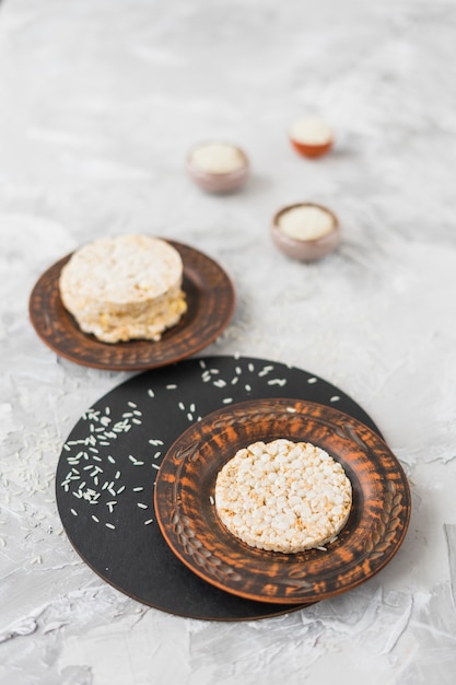 Free Photo round puffed rice cake and rice on textured backdrop