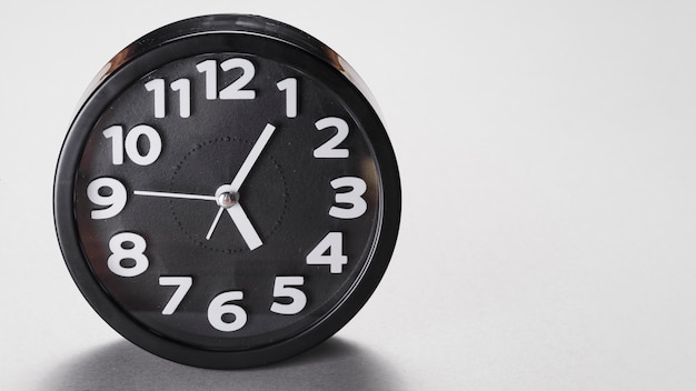 Free Photo round shape black alarm clock on gray background