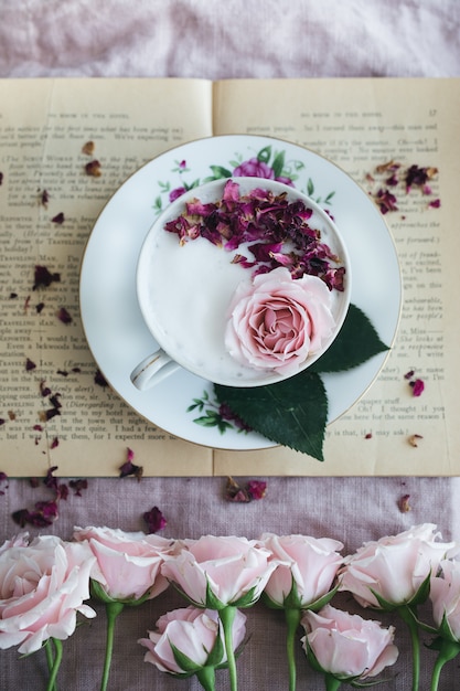 Free photo round white and pink floral plate with a cup of tea and roses