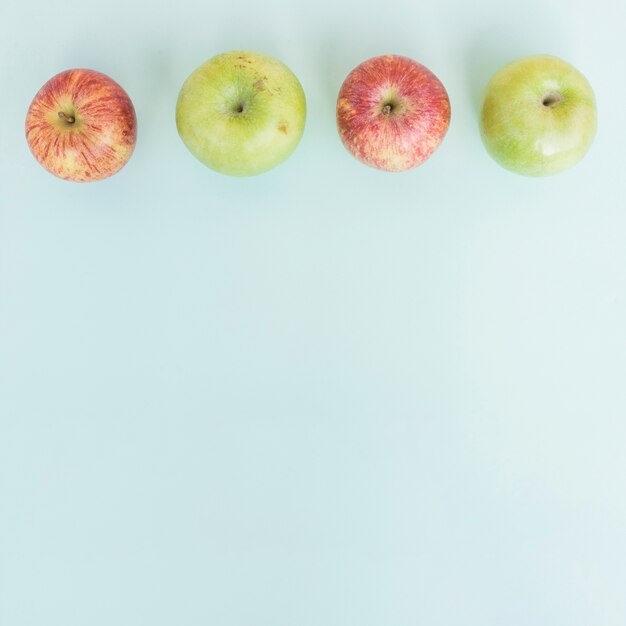 Row of apples on blue