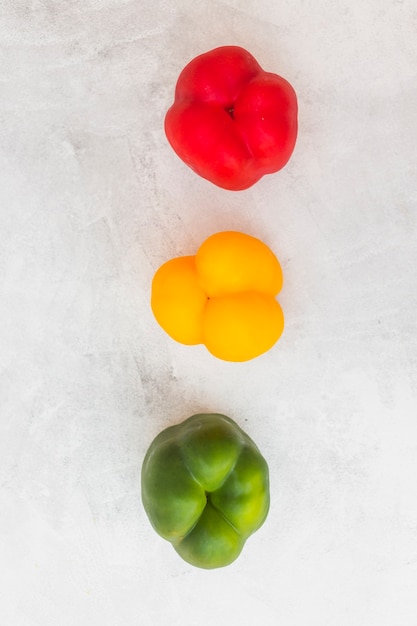 Free photo row of colorful bell peppers on white background