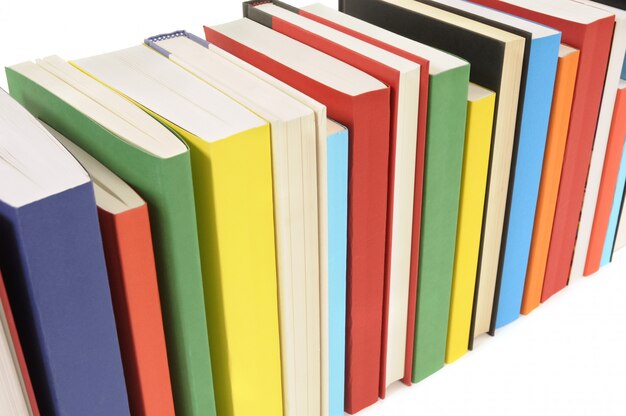 Row of colorful books set against a white background 