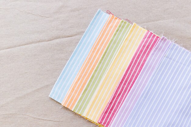 Row of colorful stripes pattern curtain samples on textile surface