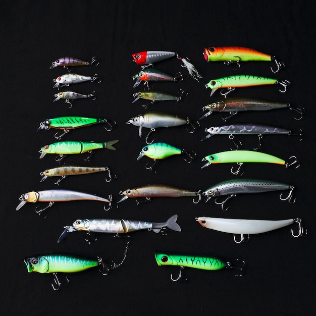 Free photo row of different fishing lure on black background