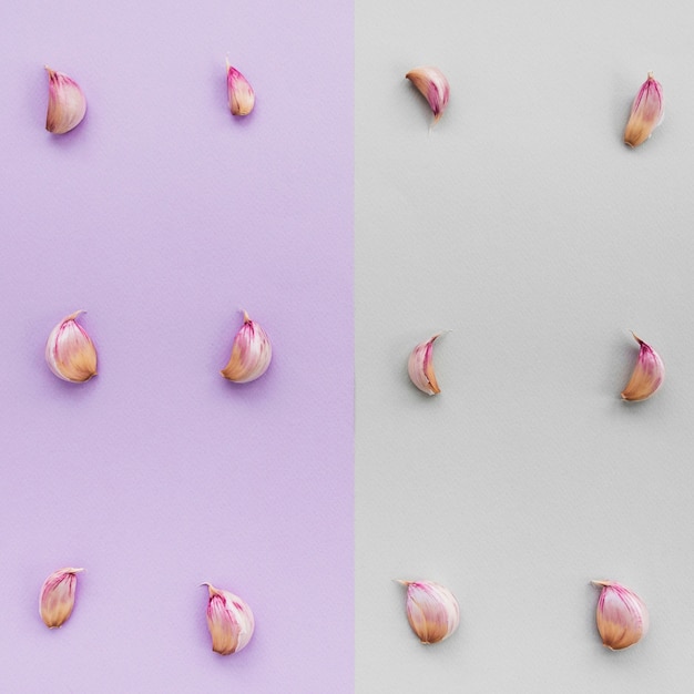 Row of garlic cloves on dual colorful background