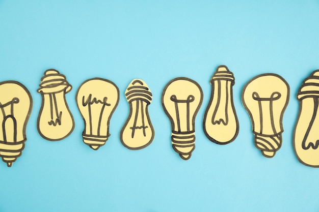 Free Photo row of hand drawn light bulbs on the middle of background