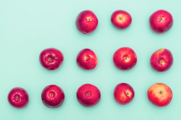 Free photo row of increasing red apples against blue background