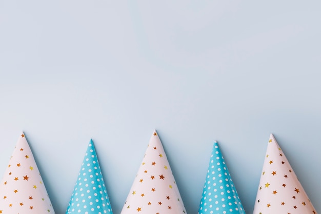 Row of party hats on blue background