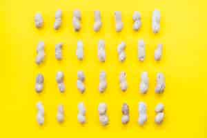 Free photo row of peanuts shell on yellow background