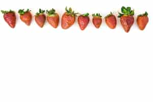 Free photo row of red strawberries on white