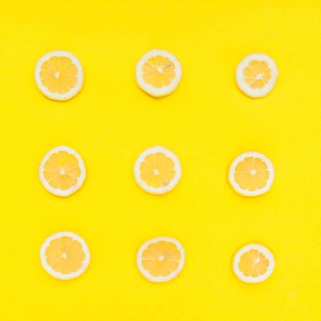 Free photo row of sliced citrus fruits on yellow background