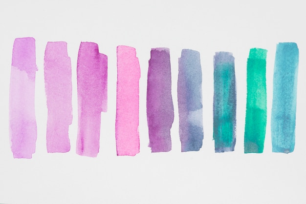 Free photo row of violet and blue paints on white paper