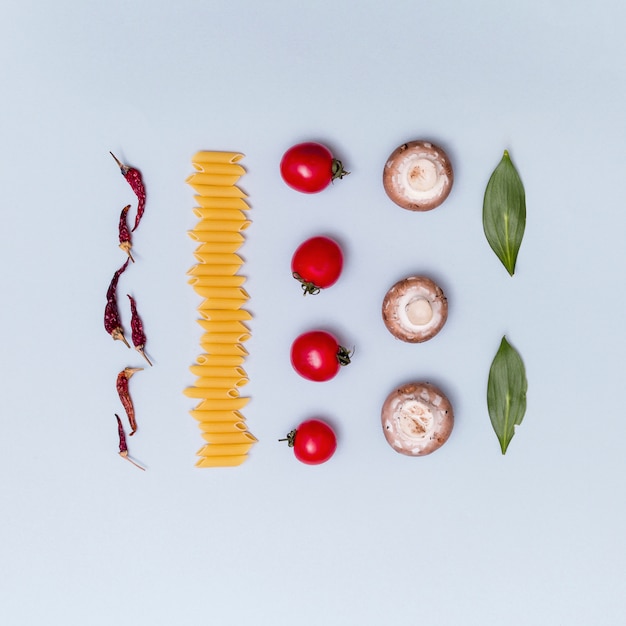 Free photo rows of fresh vegetarian uncooked pasta ingredient over gray background