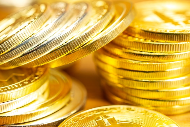 Rows and stacks of cryptocurrency coins on wooden table.