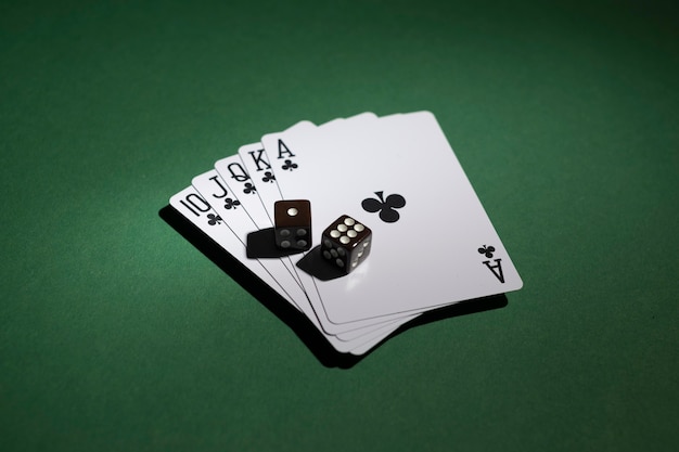 Free photo royal flush cards with dices on green background