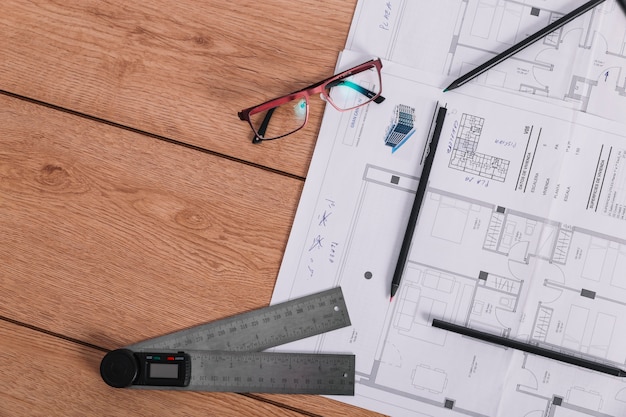 Free photo ruler and glasses near blueprint