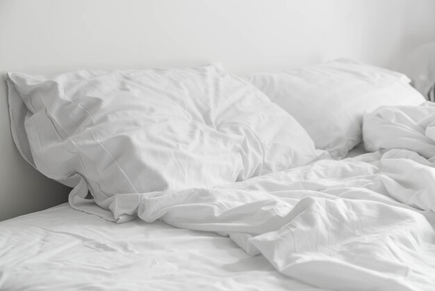 rumpled bed with white messy pillow decoration in bedroom