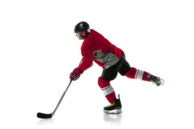 On the run. Male hockey player with the stick on ice court and white wall. Sportsman wearing equipment and helmet practicing. Concept of sport, healthy lifestyle, motion, movement, action.