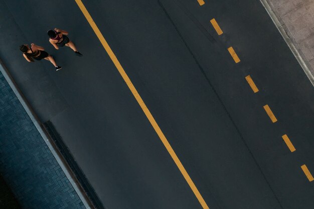 Runners running people fitness. Healthy active lifestyle. Active girls jogging together on road view from above. Summer weight loss training program.