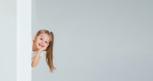 Running, jumping, having fun. Pretty caucasian girl portrait isolated on white  wall with copyspace. Concept of human emotions, youth, childhood, education, sales, facial expression.